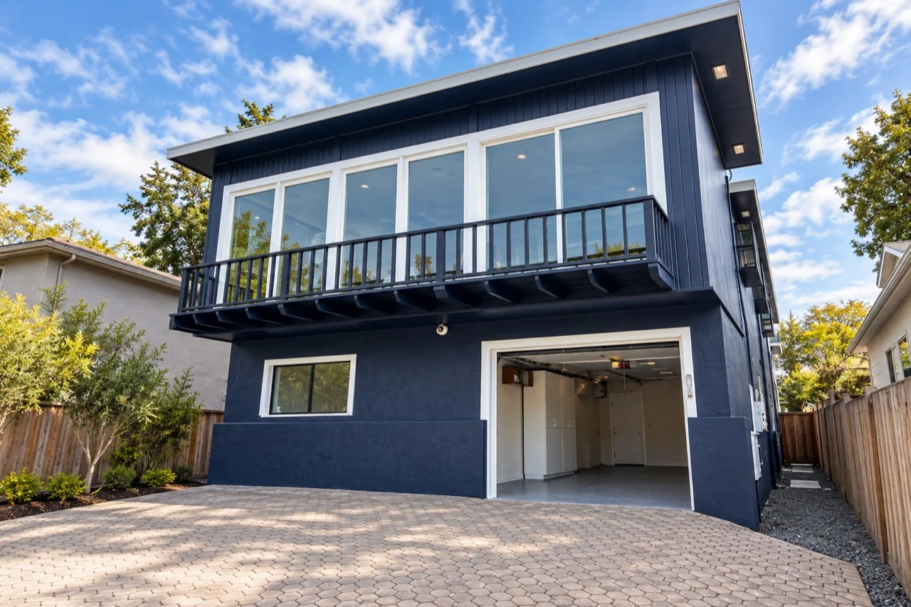 Navy home exterior with white trim and a balcony