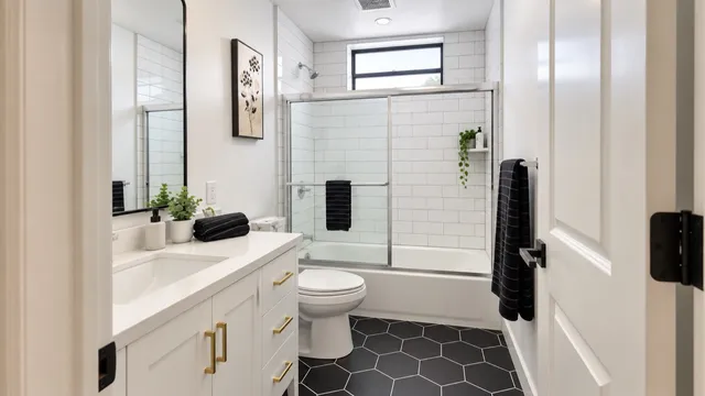 White cabinetry and subway tile balanced with dark hexagonal floor tiles.